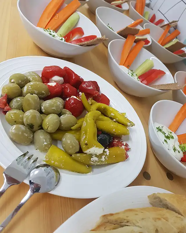 Oliven, Paprika, Gemüsesticks mit Dip und Brot bilden einen einladenden Egenberger-Aufstrich.