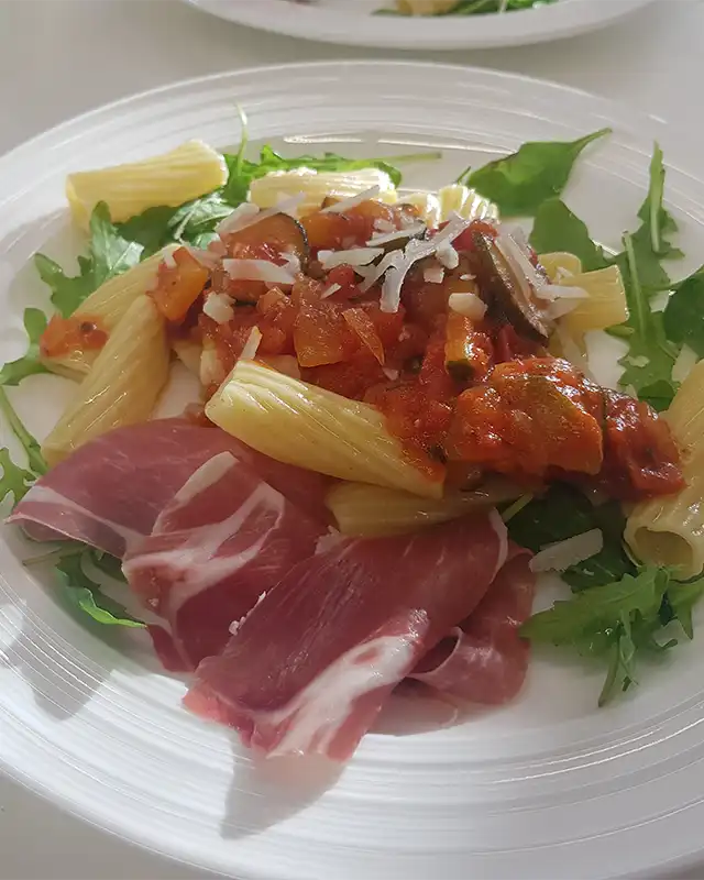 Penne mit Tomatensauce, Käse, Rucola und Prosciutto - ein klassisches Egenberger-Gericht.