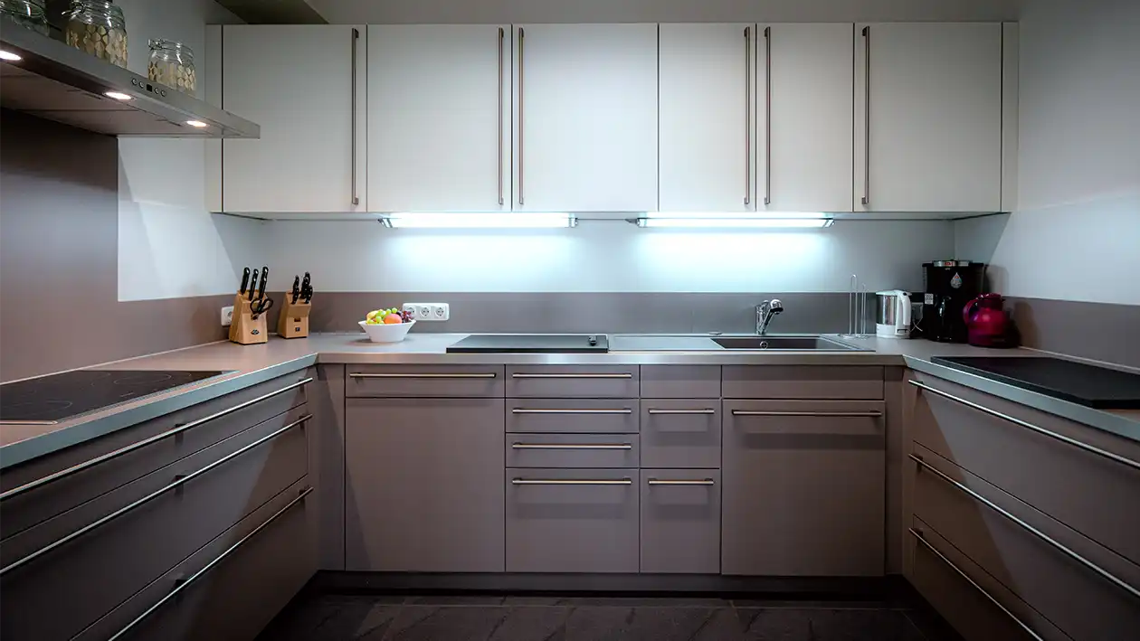 Moderne Egenberger Küche mit grauen und weißen Schränken, Spüle, Herd, Messerhalter, Obstschale.