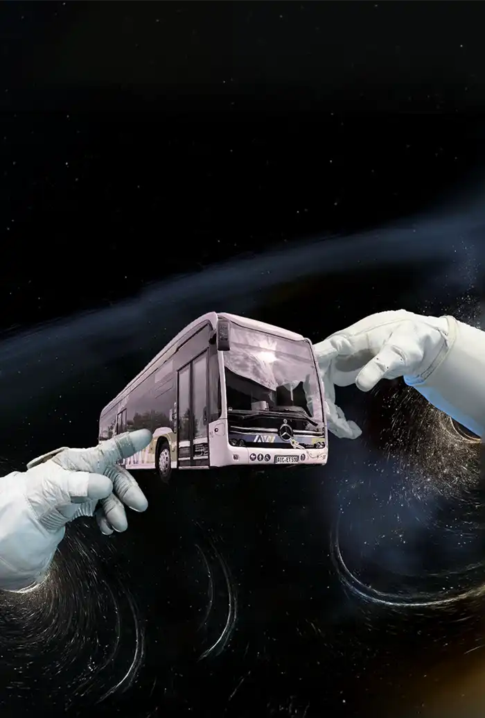 Im Weltraum halten behandschuhte Hände einen Mercedes-Benz Bus vor einem wirbelnden kosmischen Hintergrund.