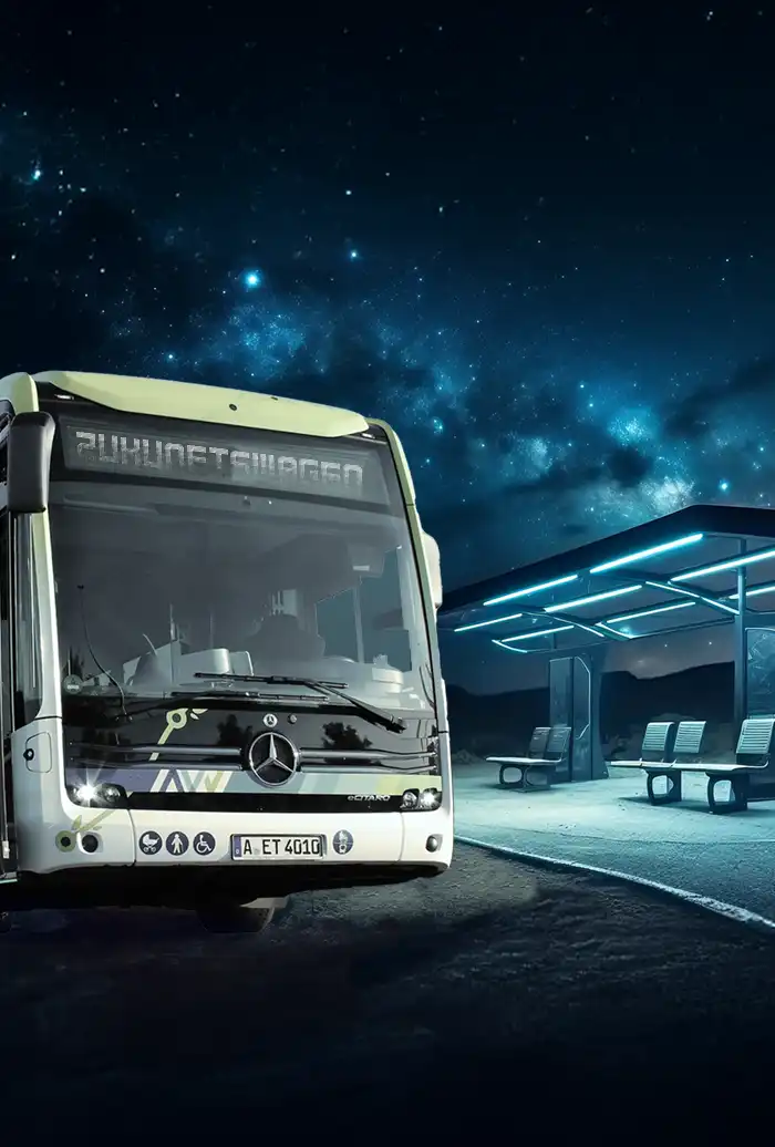 Ein weißer Mercedes-Benz-Bus an einer modernen, beleuchteten Bushaltestelle unter einem sternenklaren Nachthimmel.